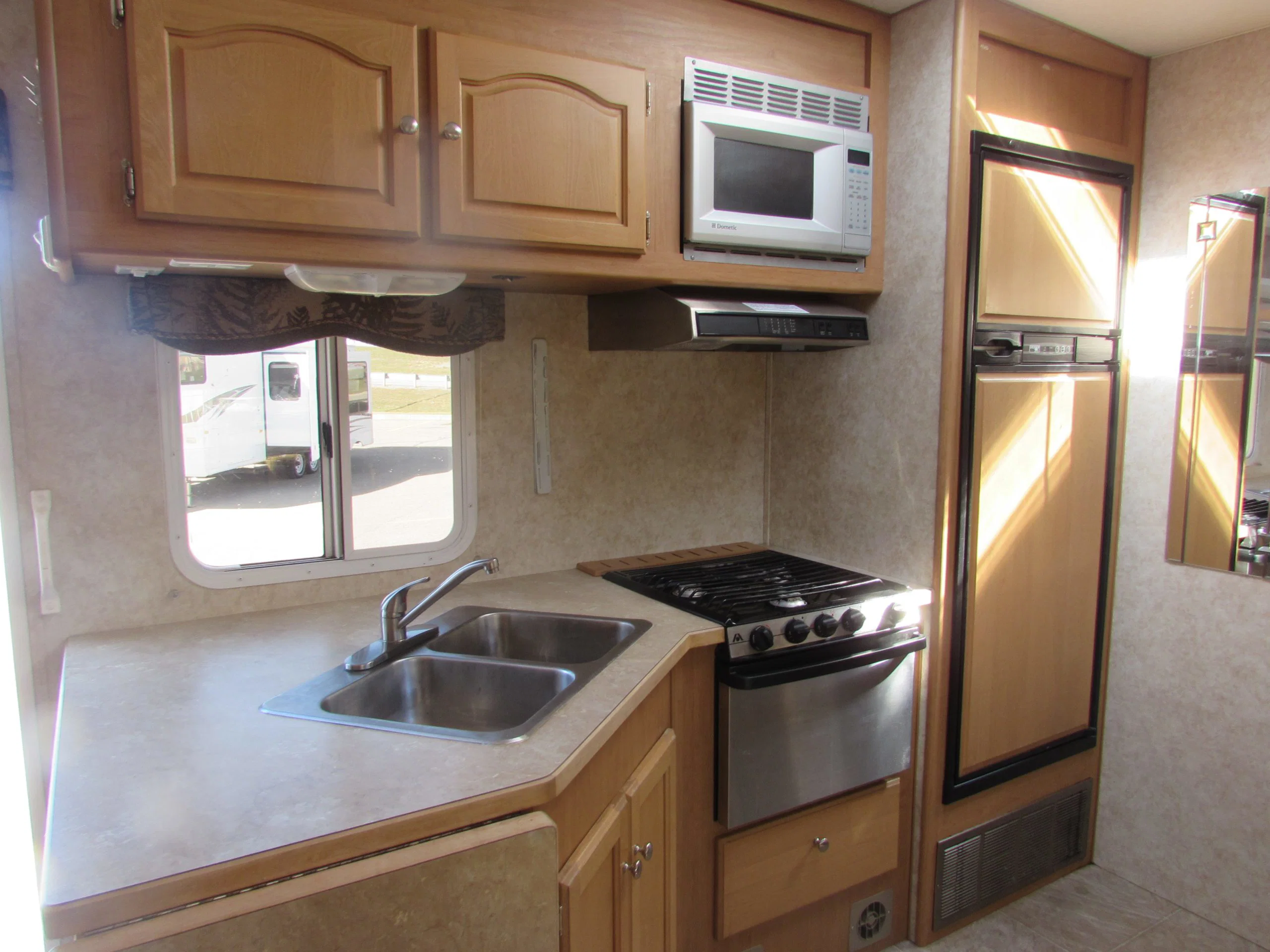 Cocina con fregadero, placa, horno y microondas